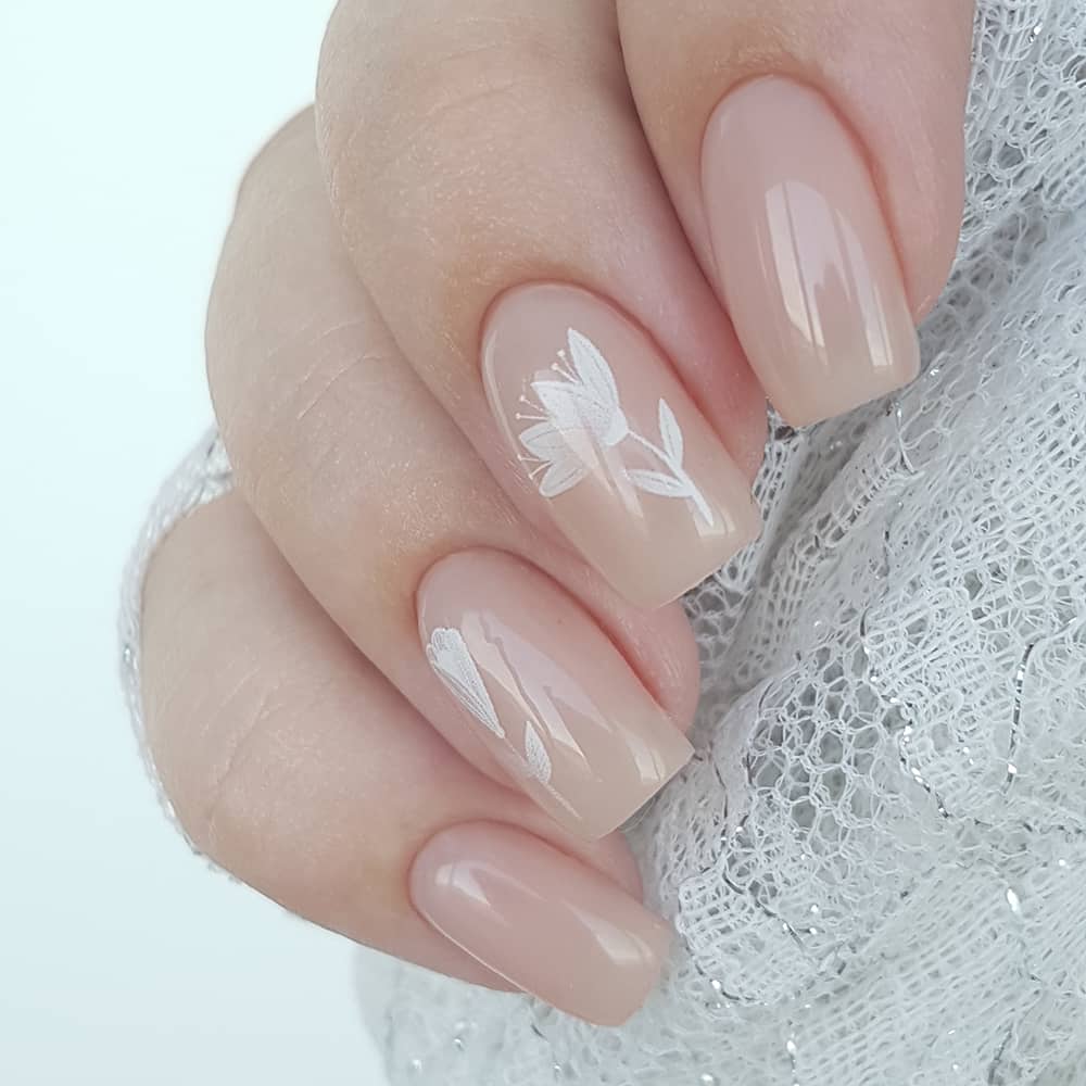 Nude manicure with white flowers